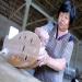 Une ouvrière ponce un objet en bambou qui sert pour la douche dans une petite usine de bambou.