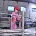 Une ouvriere fait passer des lamelles de bambou dans une machine pour les découper dans une petite usine de bambou dans la province de Zhejiang.